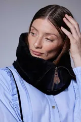 Cuello de piel sintética negra con cierre frontal y tirador de cuero, diseñado para ser usado sobre otras prendas.