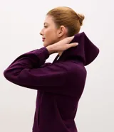 Campera deportiva de modal negro con capucha, cierre frontal por cremallera, cordones ajustables, bolsillos y mangas largas con puños elásticos.