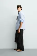Pantalón de corte regular fit confeccionado en tejido mezcla de algodón, con cintura elástica ajustable mediante cordón, bolsillos laterales y bolsillos traseros de vivo.