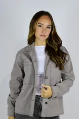 Camisa de gabardina color gris topo, con cuello camisero, bolsillos frontales con solapa y cierre de botones metálicos.