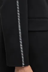 Blazer negro con bordado en contraste a lo largo de las mangas.