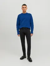 Jean slim fit de tiro bajo color negro, con diseño clásico de cinco bolsillos y cierre frontal con botón.