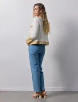 Chaqueta Nanette de tejido tweed y denim color blanco con cuello a la base y abertura central. Delantera con bolsillos, puño con aplique de botones metálicos y terminación desflecada.