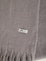 Bufanda larga color verde esmeralda, de tejido suave y textura peluda.