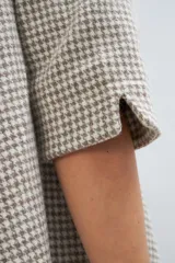 Vestido midi acampanado de lana fina sin teñir, con cuello bote, mangas tres cuartos con tajo y bolsillos laterales. Diseño forrado con vuelo y movimiento.