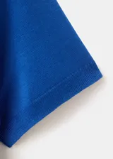 Buzo de punto color azul, con cuello polo y manga corta, de diseño recto.