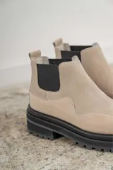 Botines Chelsea de cuero negro, con elástico lateral y suela track.