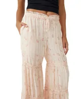 Pantalón palazzo color crema con estampado floral en tonos rosados y detalles de encaje en los ruedos.