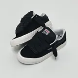 Zapatillas bajas de skate Vision Street Wear, color negro con suela blanca. Cordones anchos y etiqueta con el logo de la marca en la lengüeta.