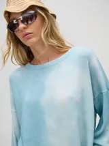 Sweater de tejido de punto con diseño holgado y largo, de manga larga con puños acanalados y aberturas laterales. Presenta un acabado con efecto desteñido.