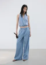 Top halter de denim suave color celeste, con escote en V cruzado y diseño corto.