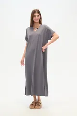 Vestido midi de corte holgado, color negro, con mangas cortas, cuello en V y detalle de cuentas decorativas en el escote.