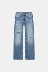 Jeans de tiro bajo y cinco bolsillos, con diseño de pierna ancha y larga. Presenta roturas y desgastes sutiles en la parte delantera. Cierre frontal con cremallera y botón metálico.