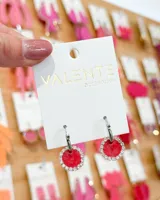 Aros colgantes con base circular roja con borde de strass plateado.