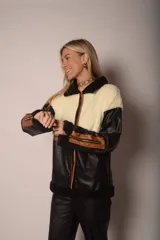 Campera negra con paneles de cuero sintético con textura de cocodrilo, corderito color crema en la parte superior y detalles en cuero marrón.