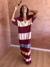 Vestido largo de tejido de punto con diseño a rayas horizontales en tonos bordó, crema, rosa y celeste. Presenta cuello polo con escote en V y mangas cortas con textura acanalada.