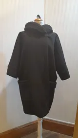 Chaquetón negro de lana tipo astracán, modelo oversize con cuello y puños de piel sintética. Cierre con un botón. Talle único hasta 2XL.