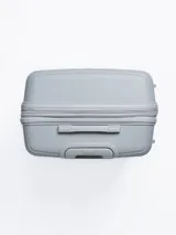 Valija rígida de viaje color gris con diseño de líneas horizontales. Cuenta con manija extensible, cuatro ruedas con giro de 360°, cierre con combinación y manija lateral.