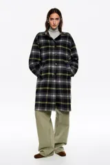 Abrigo midi de estructura envolvente confeccionado en mezcla de lana doble faz. Presenta cuello subido, cierre frontal con botones, mangas largas amplias con ajuste de botón en el puño y bolsillos laterales de vivo.