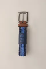 Cinturón elástico trenzado azul con detalles en azul más claro y hebilla metálica plateada con aplique de cuero marrón.