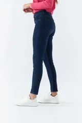 Pantalón de jean negro, corte skinny, tiro medio, con logo bordado y pasacinto.