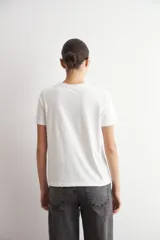 Remera blanca de manga corta con estampa damasco floral en tonos bordó y negro en el frente.