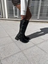 Bota negra de ecocuero con hebillas y taco de 6.5 cm.