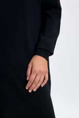 Vestido midi de punto en color negro, con cuello alto y mangas largas con puños ajustados. Presenta un diseño minimalista y entallado.