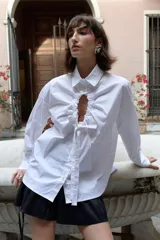 Minifalda negra de tafeta con cintura alta elastizada, diseño con volado y lazos laterales ajustables.