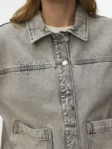 Campera de denim estilo shacket en color azul claro, con cuello clásico, cierre frontal con botones metálicos y amplios bolsillos frontales aplicados.