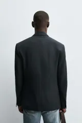 Blazer regular fit color negro, confeccionada en tejido con lyocell. Cuello con solapas de pico, manga larga con puño de botones, bolsillos de vivo en el pecho y de solapa en la cadera. Incluye bolsillo interior y abertura en el centro de la espalda. Cierre frontal de botonadura cruzada.