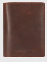 Billetera porta pasaporte de cuero natural color marrón, con diseño minimalista y logo de la marca grabado en la parte inferior. Cuenta con compartimentos internos para tarjetas y pasador para lápiz, además de tecnología de protección RFID.