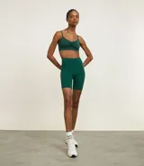 Bermuda ciclista de tiro alto confeccionada en microfibra, con ajuste ceñido al cuerpo y bolsillo funcional lateral. Presenta un diseño minimalista ideal para actividades deportivas.