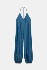 Mono largo fluido de mezcla de lyocell en color azul, con escote en V, tirantes finos tipo halter y piernas amplias con puños elásticos en los tobillos.