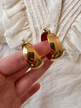 Aros tipo argolla gruesa, color dorado, de acero inoxidable.