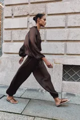 Pantalón de tiro alto con diseño abullonado, confeccionado en tejido satinado con acabado plisado y puños elásticos en los tobillos.