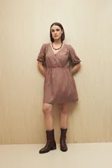 Vestido corto con estampado paisley en tonos azul marino, rosa y blanco. Tiene escote en V, mangas cortas abullonadas con puños elásticos, corte en la cintura y falda con vuelo. Incluye cinturón marrón.
