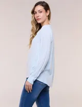 Blusa celeste fluida de viscosa, con escote en V y cuello mao, mangas largas y pliegue central en el delantero.