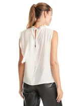 Blusa sin mangas color blanco, confeccionada en crepe con acabado satinado. Presenta un cuello alto decorado con mostacillas y una sobrecapa drapeada en el frente. La espalda cuenta con una abertura tipo gota y cierre de botón.