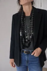 Collar largo de múltiples capas compuesto por discos circulares de madera en color negro, con diseño orgánico y liviano.