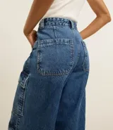 Pantalón de jean negro con corte recto, cintura alta, trabillas y bolsillos cargo laterales.