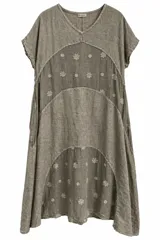 Vestido midi color visón, confeccionado en lino con escote en V, mangas cortas y diseño de paneles curvos con delicados bordados florales repartidos por toda la prenda.