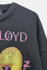 Sudadera de cuello redondo y manga larga con efecto lavado, color gris oscuro. Presenta un estampado frontal con el diseño de "The Division Bell Tour '94" de Pink Floyd y detalles estampados en las mangas. Cuenta con acabados en rib y bordes con efecto desgastado.