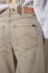 Jean color visón confeccionado en algodón sin spandex. Detalle de costura delantera con pespunte color óxido, tajo en tobillo y desflecado abajo y en bolsillos.