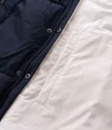Campera puffer de hombre reversible, con diseño acolchado, cuello alto, capucha y cierre frontal.