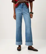 Pantalón de jean corte recto, color azul medio, con cintura alta, cierre tradicional de botón y cremallera, bolsillos funcionales y ruedo plegado en el bajo.