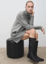 Vestido corto de punto color gris, de corte recto, con cuello vuelto y manga larga.