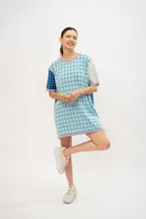 Vestido tipo remerón tejido en algodón con diseño a cuadros en tonos celeste, azul y lila.