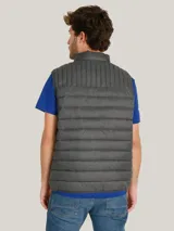 Chaleco acolchado de nailon en color gris, con cuello alto, cierre frontal de cremallera y bolsillos laterales con cierre. Presenta el logo de la marca bordado en el pecho.