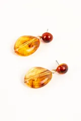 Aros colgantes con diseño de piedras en tonos ámbar y carey, compuestos por un botón superior semiesférico y un dije inferior de forma irregular.